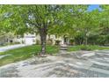 Charming home featuring a stone facade, mature trees, and a beautifully landscaped front yard at 12056 Royal Dolnoch Ct, Las Vegas, NV 89141