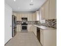 Well-lit kitchen features stainless steel appliances, and tile backsplash at 1221 Diamond Valley St, Henderson, NV 89052