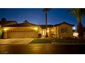 Inviting single-story home with a three-car garage and manicured front lawn at twilight at 1454 Erskine Ave, Las Vegas, NV 89123