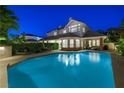 A luxurious backyard pool with a covered patio and plenty of seating, perfect for outdoor entertaining at night at 2325 Prometheus Ct, Henderson, NV 89074