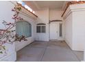 Inviting front entry featuring a covered porch with white stucco walls, tiled floor and decorative windows at 2588 Mizzoni Cir, Henderson, NV 89052