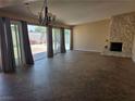Spacious living room with stone fireplace, tile flooring, and access to the backyard at 3314 Arapaho, Las Vegas, NV 89169