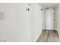 Bright hallway with a clean aesthetic, featuring wood-look flooring and modern light switch and thermostat at 3930 University Center Dr # 311, Las Vegas, NV 89119