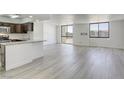 Spacious, bright living space with wood-look flooring, and an open layout to the kitchen with many windows at 3930 University Center Dr # 311, Las Vegas, NV 89119