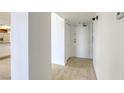 Apartment hallway with tile flooring, white walls, and a glimpse of the kitchen with stainless steel appliances at 3930 University Center Dr # 312, Las Vegas, NV 89119