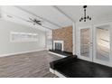 Spacious living room with a brick fireplace, ceiling fan and sliding glass doors at 4417 Saint Andrews Cir, Las Vegas, NV 89107