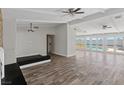 An open-concept living space with stylish wood flooring, bright windows, and doors to the pool area at 4417 Saint Andrews Cir, Las Vegas, NV 89107