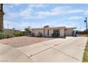Single-story home with a gravel front yard, gated entrance, and a long driveway leading to the side of the property at 4691 Sun Valley Cir, Las Vegas, NV 89122