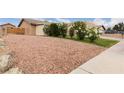 Spacious driveway with desert landscaping of rocks, flowering bushes and green grass at 4998 Rappahanock St, Las Vegas, NV 89122