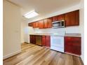 Bright kitchen with stainless steel appliances, cherry wood cabinets and wood-look flooring at 5321 River Glen Dr # 232, Las Vegas, NV 89103