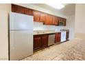 Bright kitchen with stainless steel appliances, cherry wood cabinets and wood-look flooring at 5321 River Glen Dr # 232, Las Vegas, NV 89103