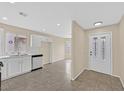 Spacious kitchen featuring stainless steel appliances and tile flooring with a view to the front door at 5820 Royal Castle Ln, Las Vegas, NV 89130