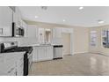 Bright kitchen with white cabinets, stainless steel appliances, tile floors and eat in nook at 5820 Royal Castle Ln, Las Vegas, NV 89130