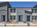 Modern two-story townhome with gray and beige stucco and well manicured landscaping at 6109 Aster Garden St # 159, North Las Vegas, NV 89081