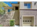 View of the condo's attached garage and stone-accented facade at 701 Peachy Canyon Cir # 201, Las Vegas, NV 89144