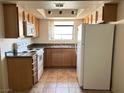 Bright kitchen features wooden cabinets, granite counters, tile floor, and white appliances at 7300 Pirates Cove Rd # 2054, Las Vegas, NV 89145