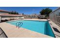 Community pool with clear water and poolside amenities under a bright blue sky at 7300 Pirates Cove Rd # 2054, Las Vegas, NV 89145