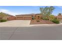A single-story house featuring a three-car garage, desert landscaping, and a wide driveway on a sunny day at 7719 Villa Montara St, Las Vegas, NV 89123
