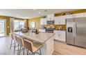 Bright kitchen boasts an island with bar stool seating, white cabinetry and stainless steel appliances at 794 Calm Crystal Ct # Lot 139, North Las Vegas, NV 89081