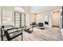 Bright living room with high ceilings, modern furniture, and wood-look flooring at 8469 Cheerful Brook Ave, Las Vegas, NV 89143