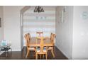 Spacious dining area features wood flooring, a decorative chandelier, and an 'EAT' accent wall, great for gatherings at 9303 Gilcrease Ave # 1077, Las Vegas, NV 89149