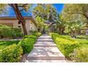 Inviting walkway leading to the property, lined with lush greenery and mature trees at 9713 Highridge Dr, Las Vegas, NV 89134