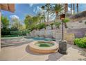 Backyard pool and spa accented by a stone waterfall feature and surrounded by lush landscaping at 9713 Highridge Dr, Las Vegas, NV 89134