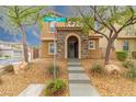 Inviting two-story home boasting a stone-accented entry and well-maintained landscaping at 9925 Turquoise Glass Ct, Las Vegas, NV 89178