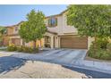 Two-story home with a two-car garage and desert landscaping at 10931 Sardinia Sands Dr, Las Vegas, NV 89141