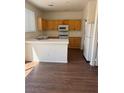 Bright kitchen featuring wooden cabinets, white appliances, and a breakfast bar at 1153 Stormy Valley Rd, Las Vegas, NV 89123