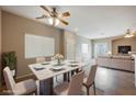 Dining room with a marble table, seating for six, a ceiling fan and lots of natural light at 1580 Wild Willey Way, Henderson, NV 89002