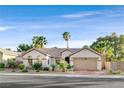 Inviting single-story home with a well-manicured lawn, desert landscaping, and attached two-car garage at 2309 Tedesca Dr, Henderson, NV 89052