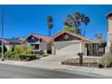Inviting single-story home with terra cotta roof, two car garage, and desert landscaping creates curb appeal at 2704 Miraflores Ave, Las Vegas, NV 89102