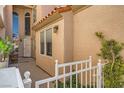 Inviting entryway with white picket fence, tall arched window, and stucco exterior at 3111 Lido Isle Ct, Las Vegas, NV 89117