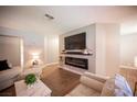 Modern living room includes hardwood floors, a sleek TV, and an electric fireplace at 3151 Soaring Gulls Dr # 1181, Las Vegas, NV 89128