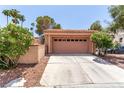 Two-car garage featuring an extended driveway and desert landscaping at 3246 Brookfield Dr, Las Vegas, NV 89120