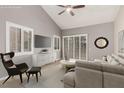 Comfortable living room features vaulted ceilings, plantation shutters, and a stylish gray sofa with modern decor at 3246 Brookfield Dr, Las Vegas, NV 89120