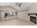 Open-concept living and kitchen area with light-tone floors, fireplace, and breakfast bar at 3246 Brookfield Dr, Las Vegas, NV 89120