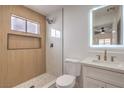 Modern bathroom showcases wood-look tile accent wall, sleek fixtures, floating vanity, and glass-enclosed shower at 40 Laswell St, Henderson, NV 89015