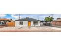 Charming single-story home with a bright orange door, low-maintenance landscaping, and covered parking area at 40 Laswell St, Henderson, NV 89015