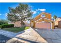 Inviting two-story home showcasing a spacious driveway, mature tree, and well-maintained lawn at 4209 Glass Lantern Dr, North Las Vegas, NV 89032