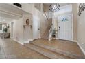 Bright foyer featuring tile floors, a staircase, and a chandelier, creating an inviting entrance at 4209 Glass Lantern Dr, North Las Vegas, NV 89032
