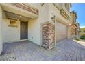 Inviting home entrance with stone accents, a paver walkway, and a two-car garage at 4503 Meteora Ledge Ave, North Las Vegas, NV 89084