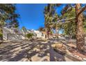 Sprawling property with a garage, long driveway, mature trees, and ample parking for multiple vehicles at 5715 Gilbert Ln, Las Vegas, NV 89130