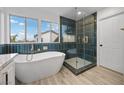 Beautiful bathroom features a soaking tub and glass shower with green tile and gold accents at 575 Dusty Palms Ln, Henderson, NV 89052