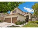 Lovely two-story home with a three-car garage and well-maintained landscaping under a bright blue sky at 575 Dusty Palms Ln, Henderson, NV 89052
