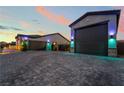 Spacious three-car garage with large paved driveway and exterior lighting at 5865 Alice Landing Ct, Las Vegas, NV 89149