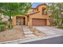 Inviting stucco home with a tiled roof, balcony, attached garage, desert landscaping, and an attractive front entrance at 617 Apricot Rose Pl, Las Vegas, NV 89138