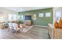 Well-lit living room with modern furnishings, a cozy rug, and a serene green accent wall at 6525 Cinnamon Hazelnut St # Lot 92, North Las Vegas, NV 89084