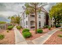 Condo building exterior with well-maintained landscaping, featuring sidewalks and leafy trees at 700 Carnegie St # 3913, Henderson, NV 89052